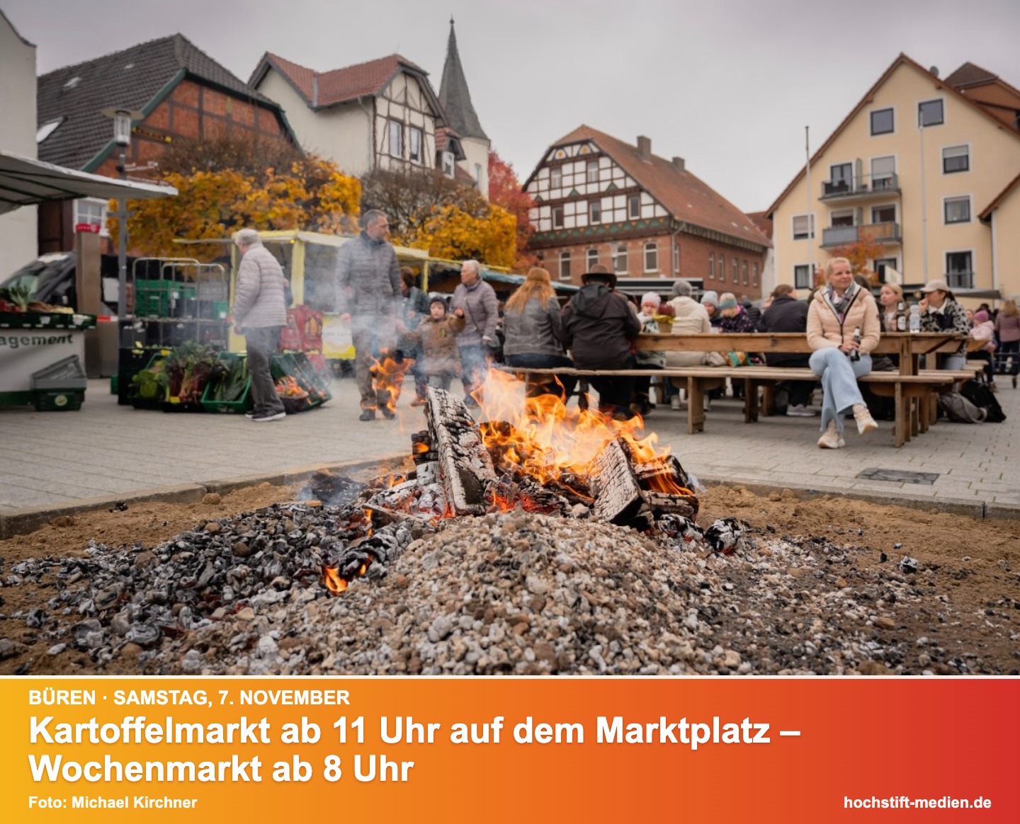 Kartoffelfeuer auf dem Bürener Marktplatz, dahinter Marktstände und Fachwerkhäuser – mit Kurzinfo