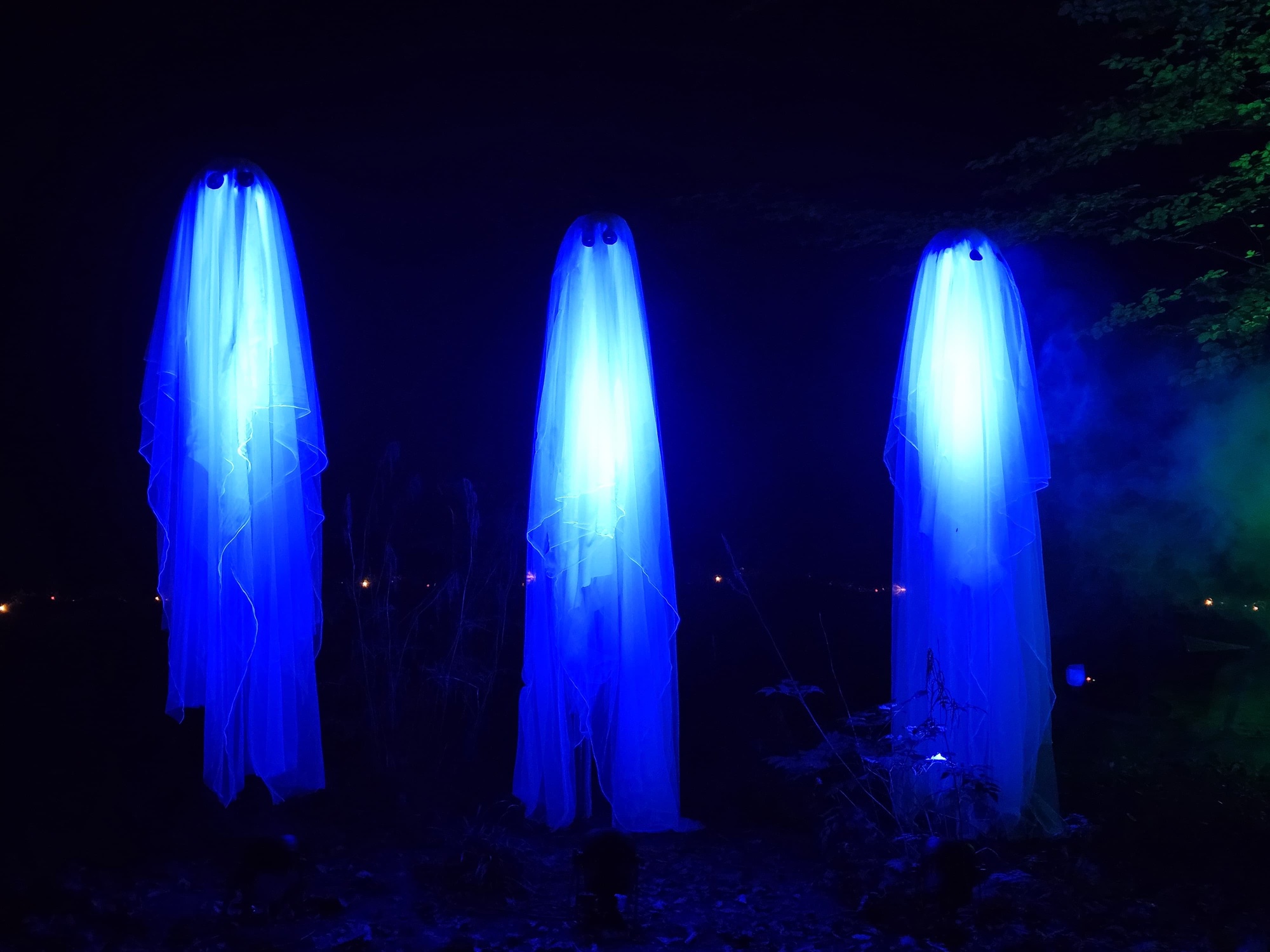 Drei blau beleuchtete Geisterfiguren