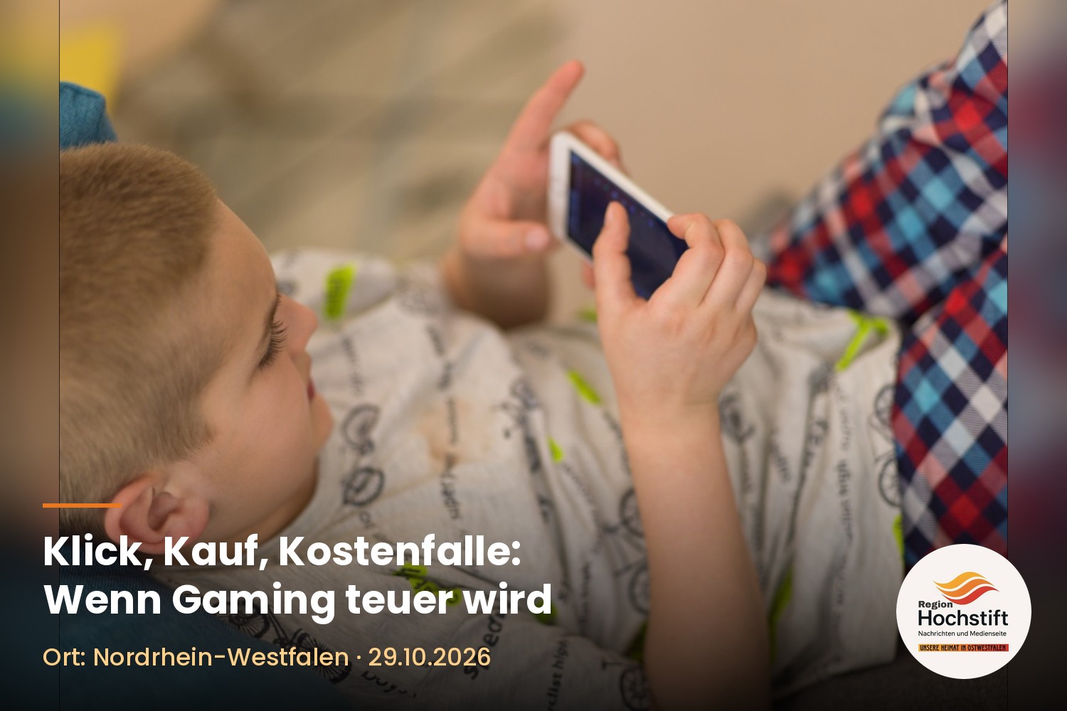 Ein Junge liegt auf dem Sofa und spielt auf einem Smartphone